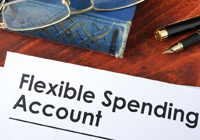 Pair of eye glasses, a book, and pen sitting on a table