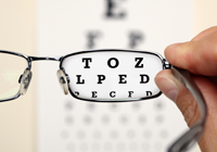 Pair of eye glasses looking at an eye chart