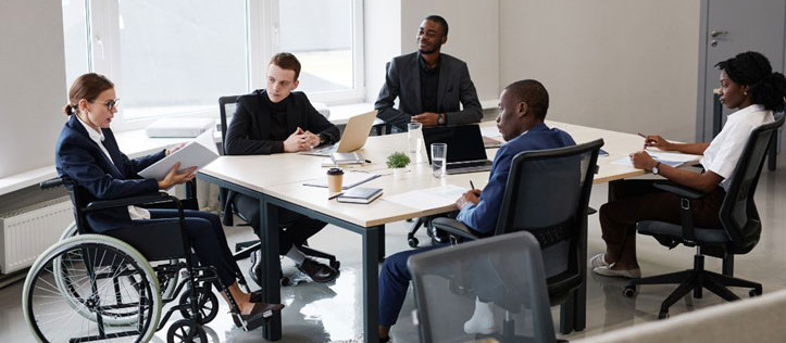 Woman in a wheelchair meeting with co-workers.