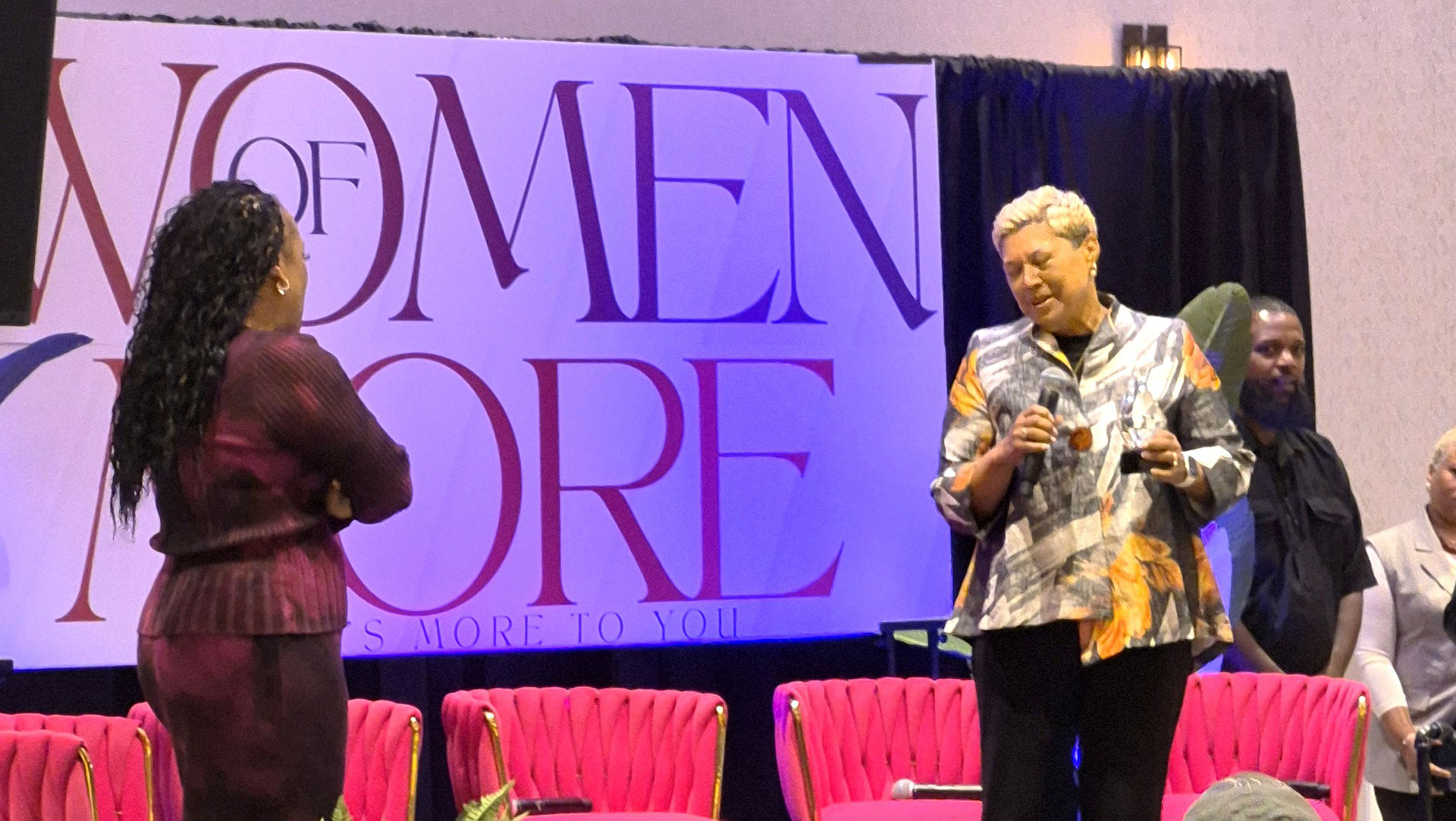 Two women doing a demonstration at the Women of More Summit event.