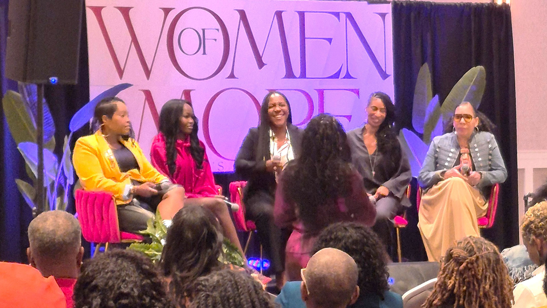 A panel of five women answering questions at the Women of More Summit event.
